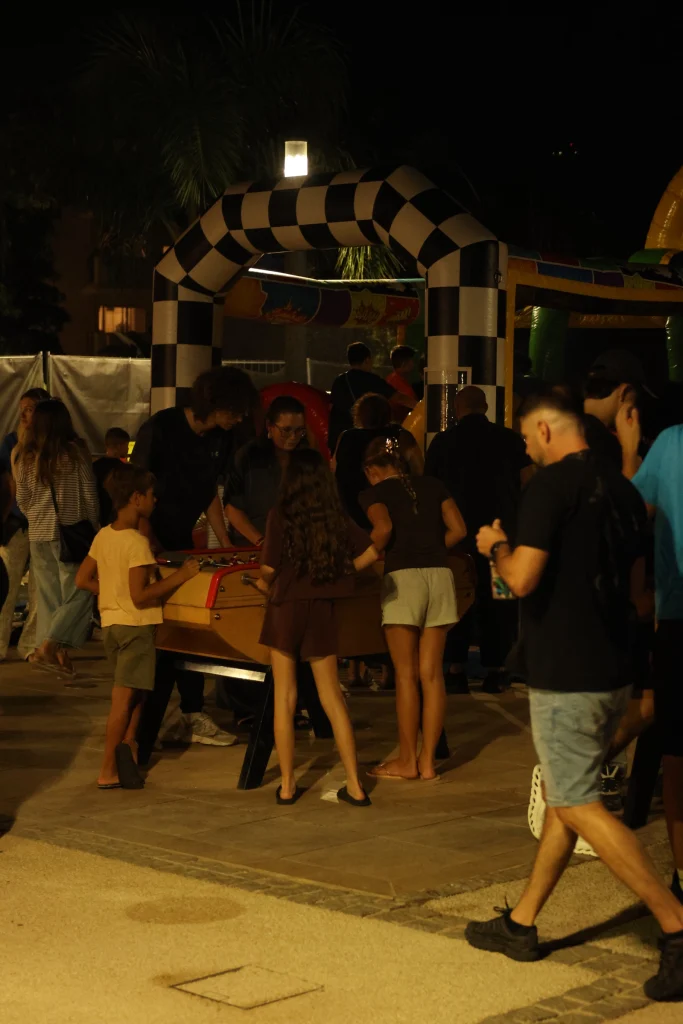 Le public de nuit au parc du Béal, devant l’arche à damier, O’Mazette 2026
